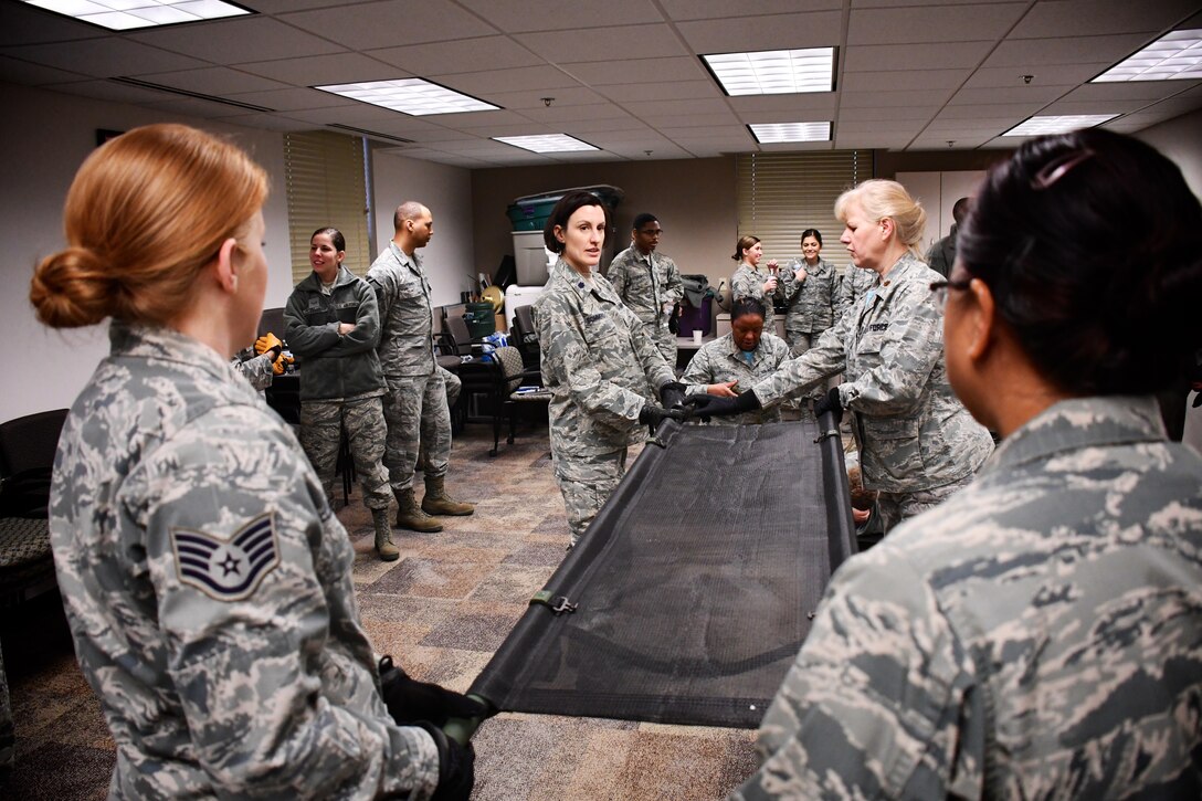 Airmen are all business as self aid and buddy care classes with litter carries takes place recently, at the 932nd Airlift Wing, Scott Air Force Base, Ill. Here, a group of 932nd Aeromedical Staging Squadron (ASTS) members practice proper lifting techniques to move up with their litter, and potentially load any type of vehicle for patient movement. The 932nd Airlift Wing worked improving and refining skills at the unit during the Unit Training Assembly weekend at Scott Air Force Base. The compact, highly-packed training was designed to lead people and maintain skills for these medical professionals of the 932nd Medical Group. (U.S. Air Force photo by Lt. Col. Stan Paregien)