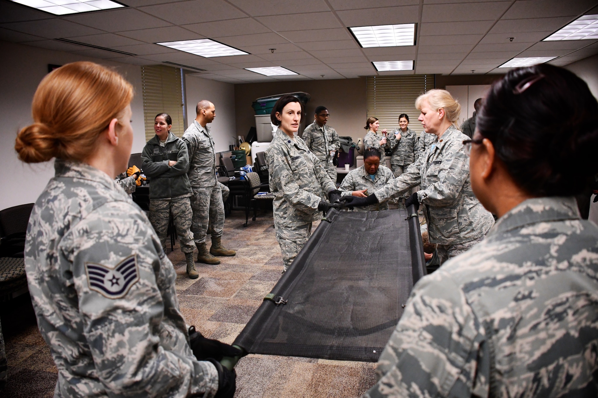 Airmen are all business as self aid and buddy care classes with litter carries takes place recently, at the 932nd Airlift Wing, Scott Air Force Base, Ill. Here, a group of 932nd Aeromedical Staging Squadron (ASTS) members practice proper lifting techniques to move up with their litter, and potentially load any type of vehicle for patient movement. The 932nd Airlift Wing worked improving and refining skills at the unit during the Unit Training Assembly weekend at Scott Air Force Base. The compact, highly-packed training was designed to lead people and maintain skills for these medical professionals of the 932nd Medical Group. (U.S. Air Force photo by Lt. Col. Stan Paregien)