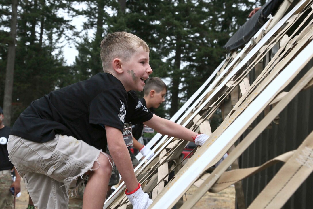 A child climbs a ladder made from straps.