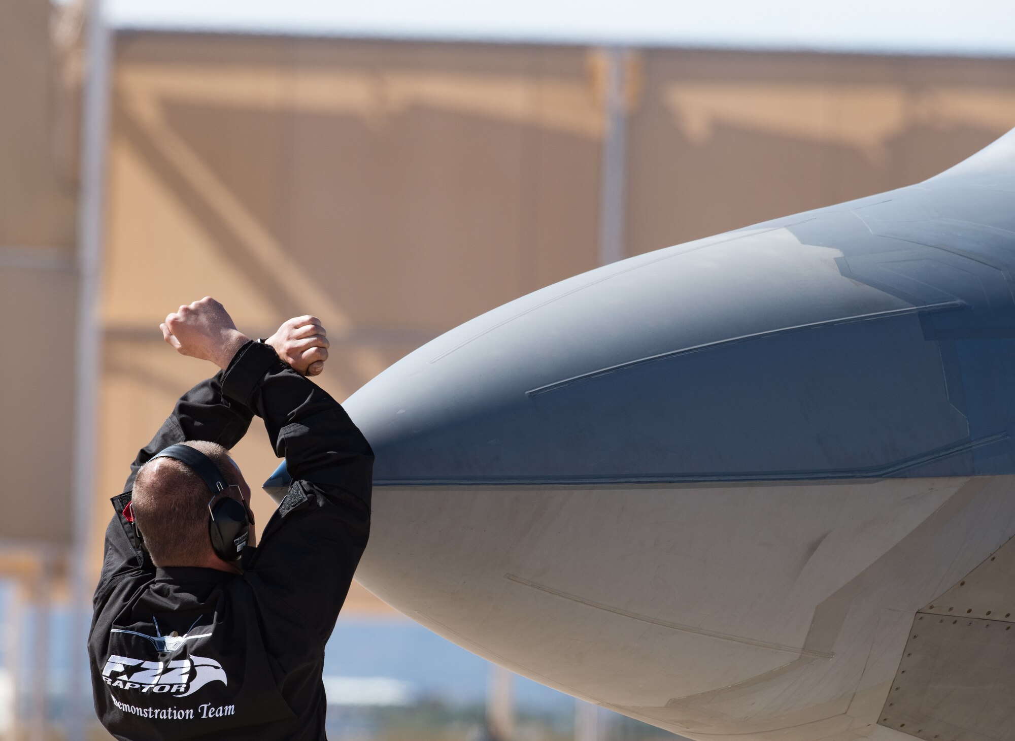 An Air Combat Command F-22 Raptor Demonstation Team crew chief directs parking an F-22 Raptor post-flight at the Heritage Flight Training Course at Davis-Monthan Air Force Base, Arizona, March 1, 2017.