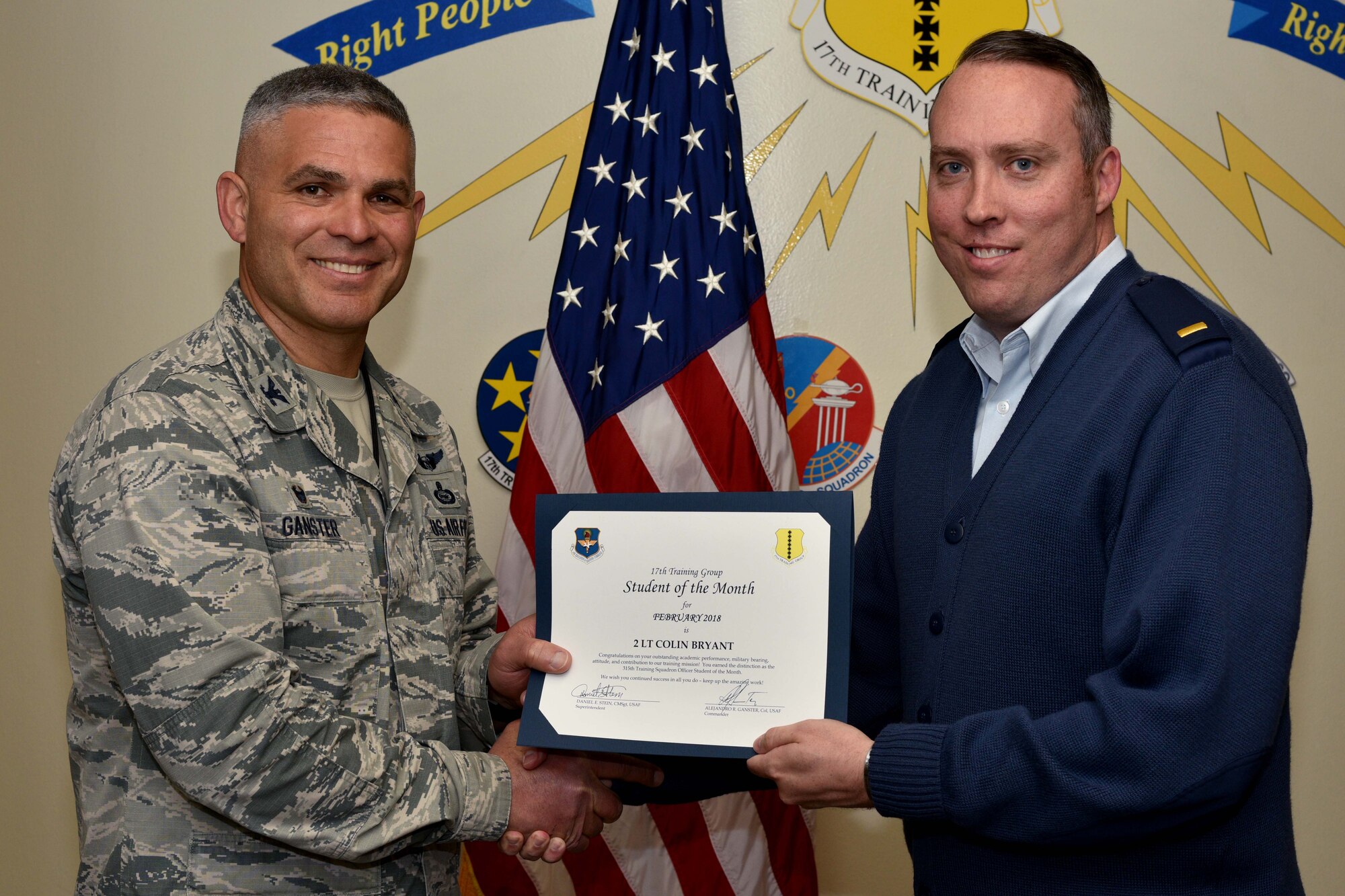 U.S. Air Force Col. Alex Ganster, 17th Training Group commander, presents the 17th TRG Student of the Month certificate to 2nd Lt. Colin Bryant, 315th Training Squadron trainee, in Brandenburg Hall on Goodfellow Air Force Base, Texas, March 2, 2018. The 315th TRS’s vision is to develop combat-ready intelligence, surveillance and reconnaissance professionals and promote an innovative squadron culture and identity unmatched across The U.S. Air Force. (U.S. Air Force photo by Senior Airman Randall Moose/Released)