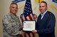 U.S. Air Force Col. Alex Ganster, 17th Training Group commander, presents the 17th TRG Student of the Month certificate to 2nd Lt. Colin Bryant, 315th Training Squadron trainee, in Brandenburg Hall on Goodfellow Air Force Base, Texas, March 2, 2018. The 315th TRS’s vision is to develop combat-ready intelligence, surveillance and reconnaissance professionals and promote an innovative squadron culture and identity unmatched across The U.S. Air Force. (U.S. Air Force photo by Senior Airman Randall Moose/Released)