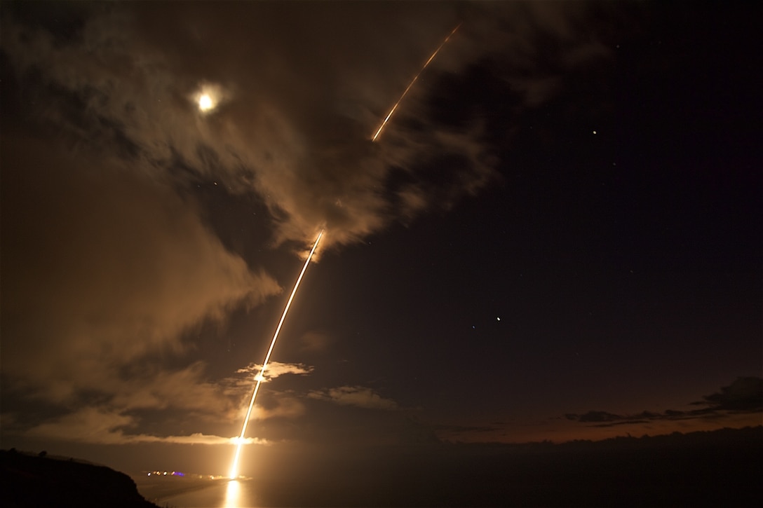 A ballistic missile target leaves a fiery arc in the night sky.
