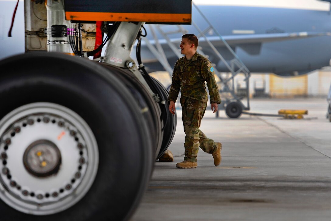 An airman conducts pre-flight checks on a KC-10 Extender aircraft.