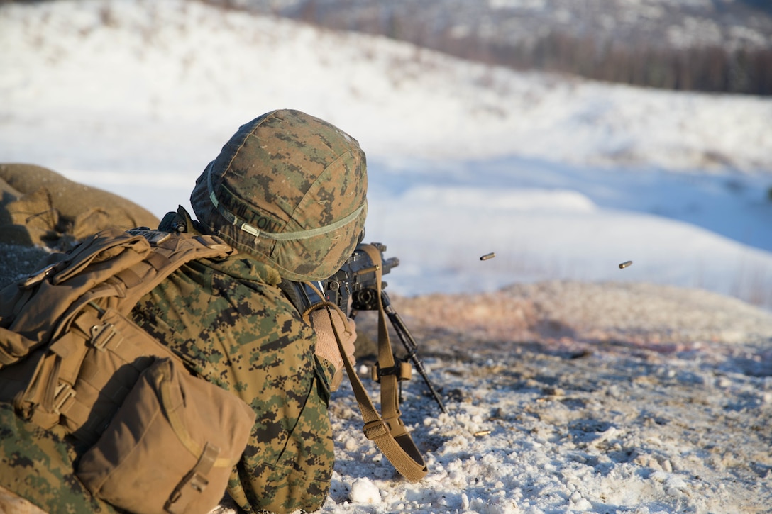 U.S. Marine Corps Lance Cpl. Wesley Hamilton with Kilo Company, 3rd Battalion, 8th Marine Regiment, 2nd Marine Division fires his M27 Infantry Automatic Rifle (IAR) at targets during Infantry Squad Battle Course (ISBC) range on Joint Base Elmendorf-Richardson (JBER), Ala., March 5. 2018. Marines with Kilo Co. conduct squad attacks during ISBC for Arctic Edge-18 in order to enhance combat readiness and effectiveness in an extreme cold weather environment.