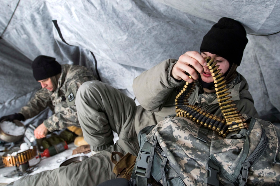 A soldier prepares an ammo belt.
