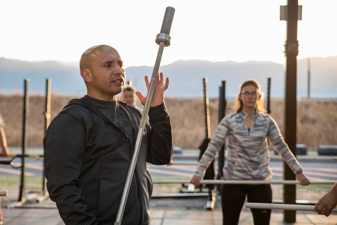 U.S. Marine Corps Chief Warrant Officer 3 Enrique Laguna, the Marine Corps Air Station (MCAS) Iwakuni telephone systems officer with Headquarters and Headquarters Squadron, instructs a High Intensity Tactical Training (HITT) session at MCAS Iwakuni, Japan, March 6, 2018. Laguna instructs HITT classes three times a day to help Marines, and anyone else on the air station, achieve and surpass their fitness goals.