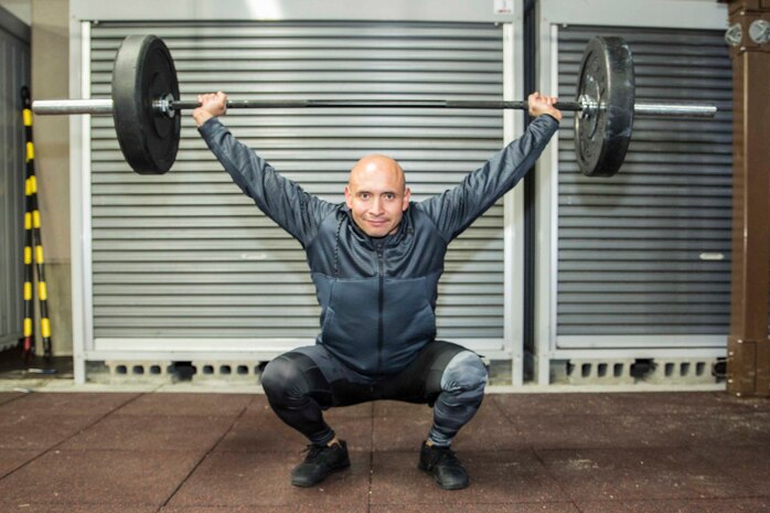 U.S. Marine Corps Chief Warrant Officer 3 Enrique Laguna, the Marine Corps Air Station (MCAS) Iwakuni telephone systems officer with Headquarters and Headquarters Squadron, executes an overhead squat during a High Intensity Tactical Training session at MCAS Iwakuni, Japan, March 6, 2018. Laguna instructs HITT classes three times a day to help Marines, and anyone else on the air station, achieve and surpass their fitness goals.