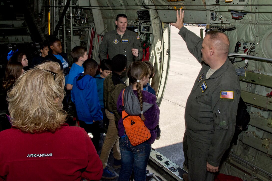 U.S. Air Force Reserve Senior Master Sgt. John Shirey, the loadmaster noncommissioned officer in charge for the 327th Airlift Squadron, and Lt. Col. Scott Lawson, director of operations, 327th AS, explain to a group of fourth graders, the procedures a paratrooper uses to jump out of a C-130J Super Hercules, Mar. 6, 2018, at Little Rock Air Force Base, Ark.