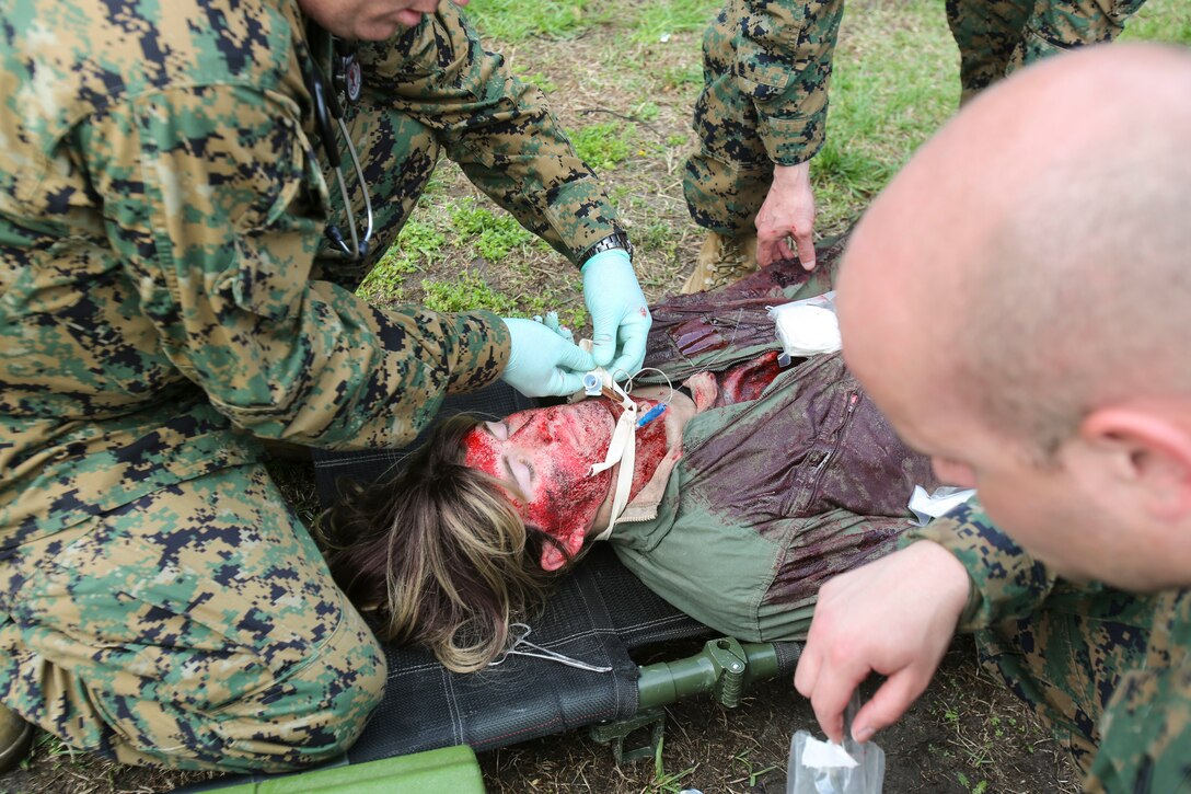 U.S. Navy doctors and hospital corpsmen with 2nd Medical Battalion, 2nd Marine Logistics Group, simulate opening the airway of a wounded service member during a certification exercise at Camp Lejeune, N.C., March 1, 2018.  The exercise was designed for shock trauma platoons and forward resuscitation surgical units to ensure medical proficiency in handling emergencies in future deployments.