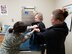 Kerwin administers a nasal vaccine to Sadie, and her mom, Jessica, and Demarse help. (U.S. Air Force photo/Laura McGowan)