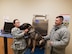 Dr. Cassandra Kerwin checks Casey’s lymph nodes, following his surgery and ongoing recovery, as his handler, Staff Sgt. Curtis Shannon, with the 88th Security Forces Squadron, looks on. (U.S. Air Force photo/Laura McGowan)