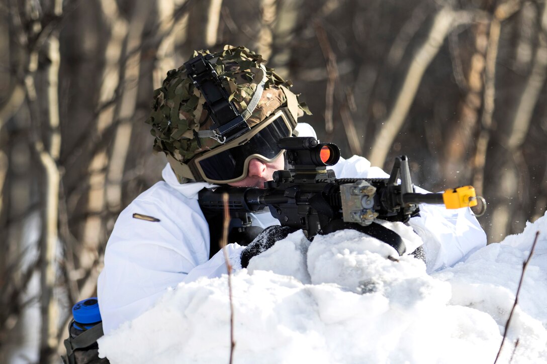 A soldier fires blank rounds during cold weather survival training.