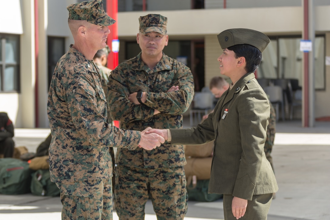 U.S. Marine Col. Jeffery Holt, commanding officer, School of Infantry - West, and Sgt. Maj. Jonathon Groth, School of Infantry - West sergeant major, greets Pvt. Nathalie Lizama. She is the second female to arrive at SOI - W on Camp Pendleton, Calif., March 6, 2018. This marks the first male-female integrated Marine Combat Training company on the West Coast.