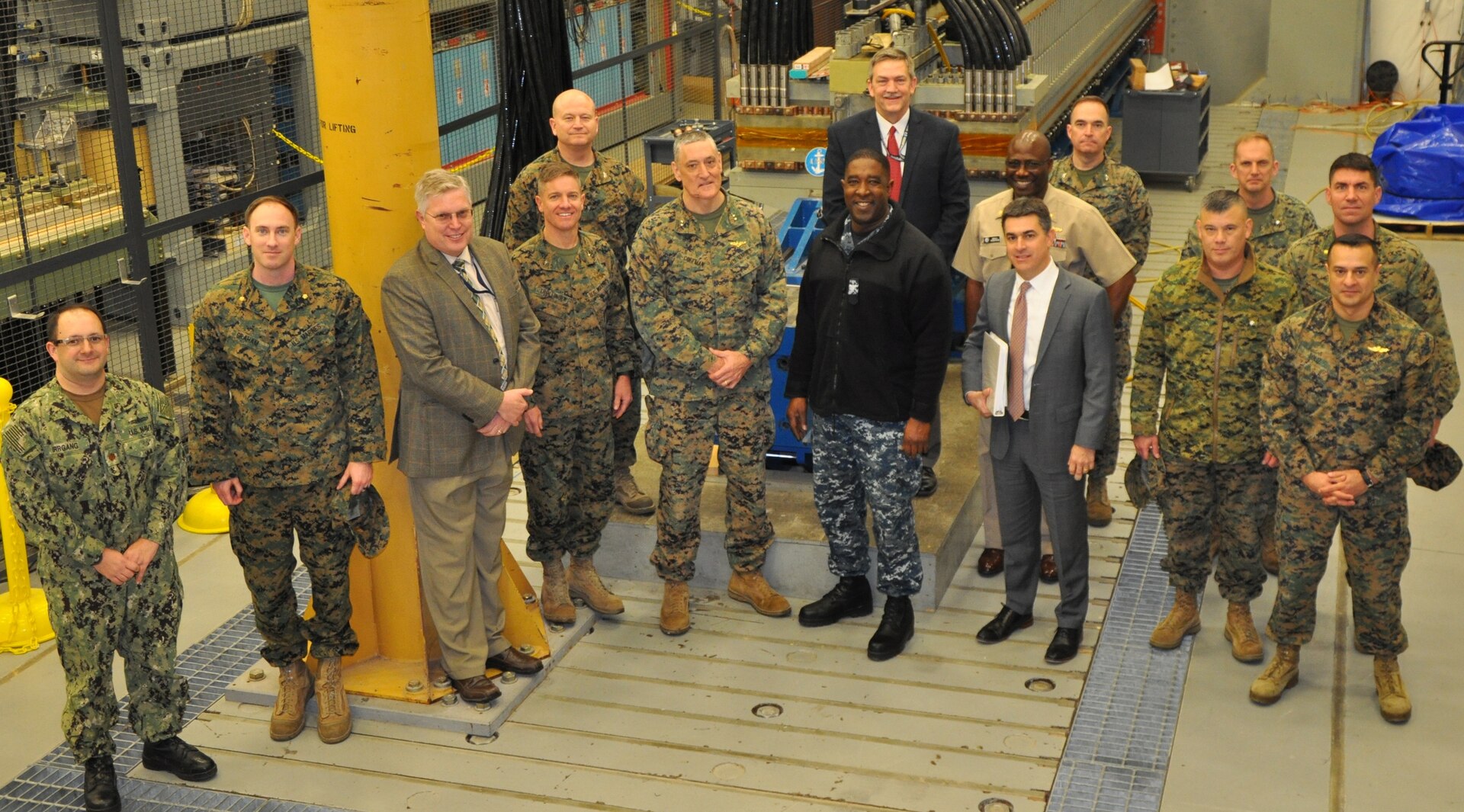 IMAGE: DAHLGREN, Va. (Feb, 23, 2018) - U.S. Marine Corps officers led by Maj. Gen. David Coffman, center, and pictured to his left, Brig. Gen. Matt Trollinger, join Capt. Godfrey 'Gus' Weekes, Naval Surface Warfare Center Dahlgren Division (NSWCDD) commanding officer, center next to Coffman, and NSWCDD leadership in front of the Navy's electromagnetic railgun prototype launcher. NSWCDD engineers briefed the Marine Corps leaders on electromagnetic launchers, hypervelocity projectiles, directed energy weapons, unmanned autonomous systems, and the 155mm moving target artillery round. The Marines saw NSWCDD facilities and the command's capability to develop and integrate complex warfare systems, including the ability to incorporate electric weapons technology into existing and future fighting forces and platforms. Coffman is the director of the U.S. Navy Expeditionary Warfare Division. Trollinger is the Operations Division director for Plans, Policies, and Operations at U.S. Marine Corps Headquarters. Dale Sisson, NSWCDD deputy technical director, is pictured to Weekes' right. Tom Boucher, Office of Naval Research Railgun Program manager, is pictured to the left of Trollinger. Chester Petry, NSWCDD electromagnetic railgun lead systems engineer, stands center back row.