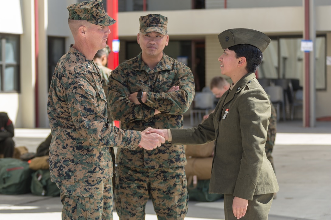 U.S. Marine Col. Jeffery Holt, commanding officer, School of Infantry - West, and Sgt. Maj. Jonathon Groth, School of Infantry - West sergeant major, greets Pvt. Nathalie Lizama. She is the second female to arrive at SOI - W on Camp Pendleton, Calif., March 6, 2018. This marks the first male-female integrated Marine Combat Training company on the West Coast.