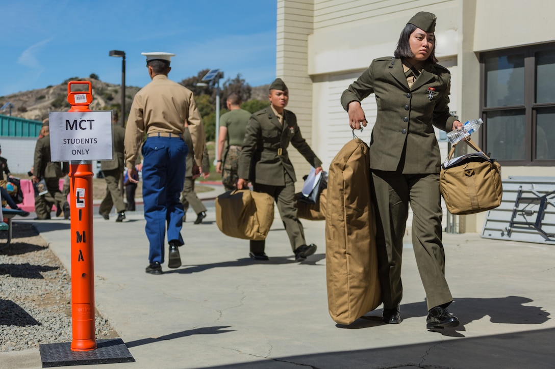 U.S. Marines walk off the bus to start their check-in process for Marine Combat Training at the School of Infantry - West on Camp Pendleton, Calif., March 6, 2018. This marks the first male-female integrated Marine Combat Training company on the West Coast.