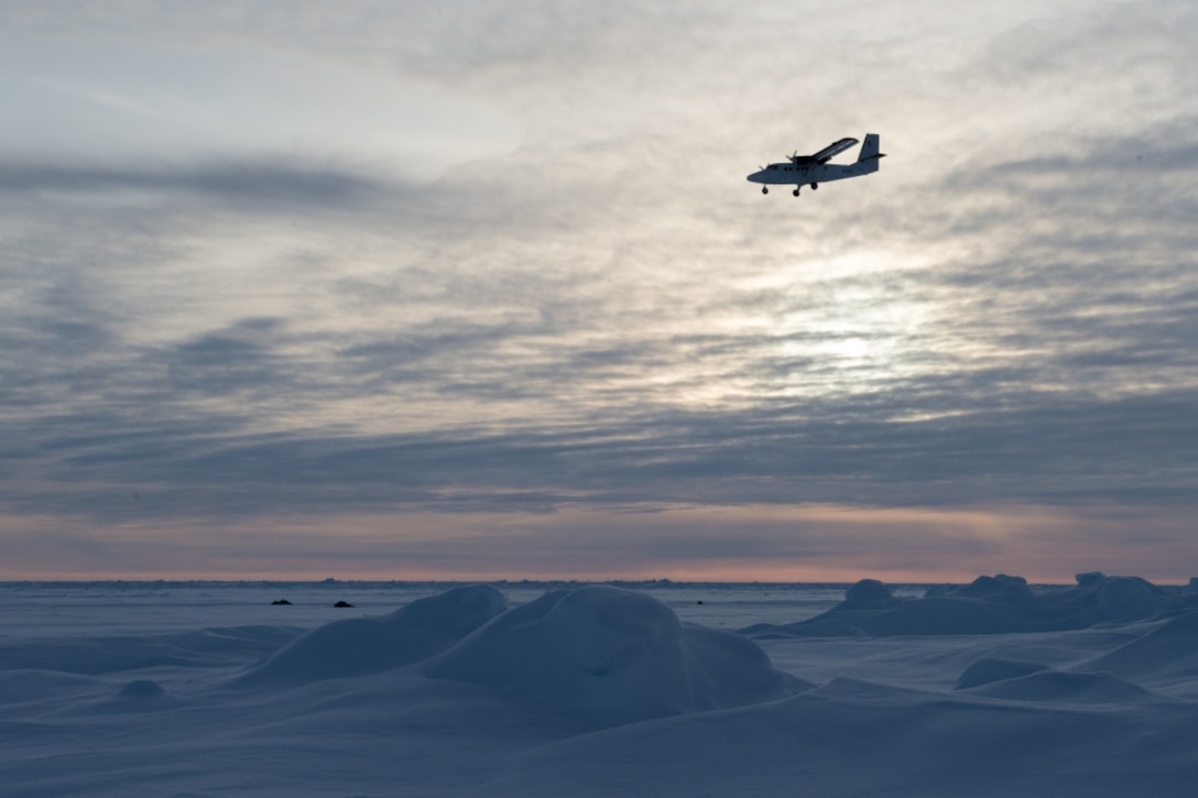 A Royal Canadian Air Force DHC-6 Twin Otter aircraft delivering supplies and personnel flies over an ice floe during Ice Exercise 2018 in the Arctic Circle.