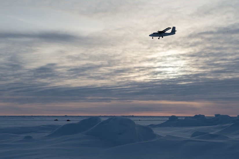 A Royal Canadian Air Force DHC-6 Twin Otter aircraft delivering supplies and personnel flies over an ice floe during Ice Exercise 2018 in the Arctic Circle.