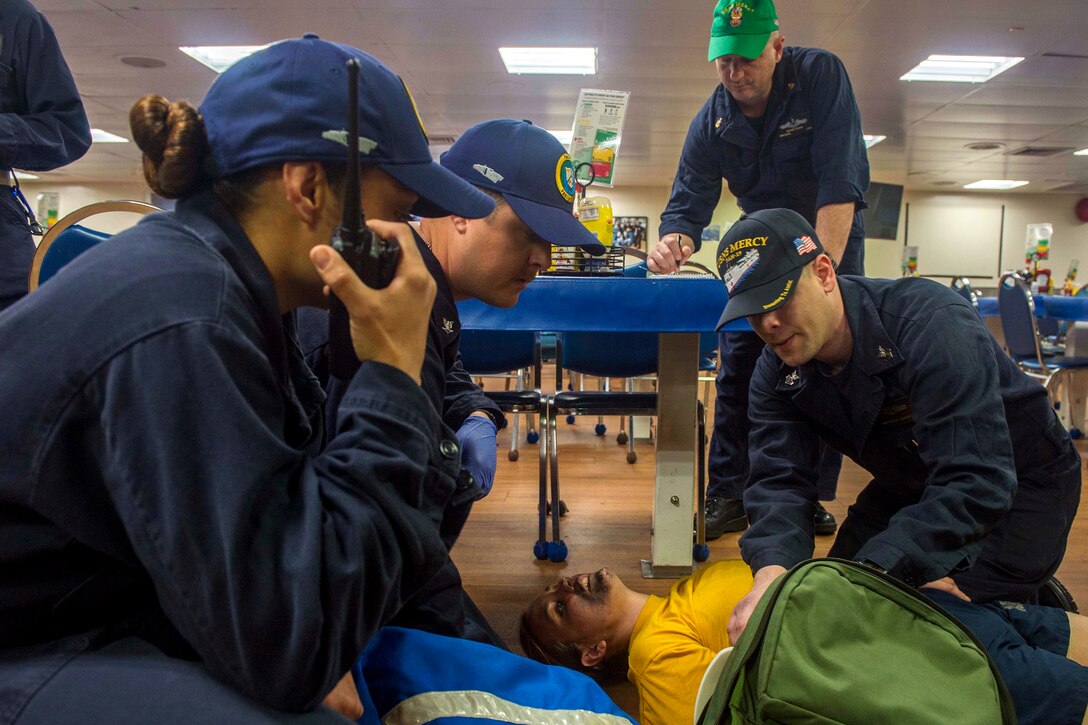 Sailors assess a simulated trauma patient during a mass casualty drill.