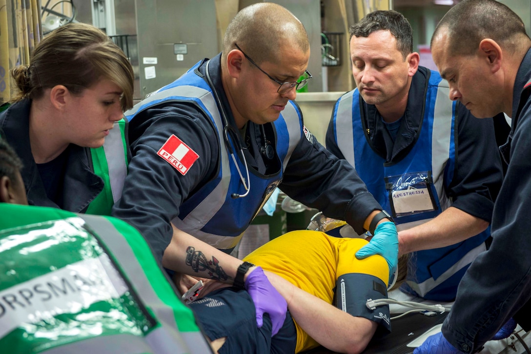 Sailors assess a simulated trauma patient during a mass casualty drill.