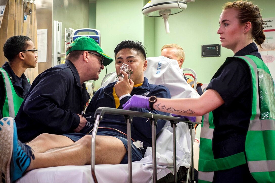 U.S. sailors provide medical aid to a simulated trauma patient.