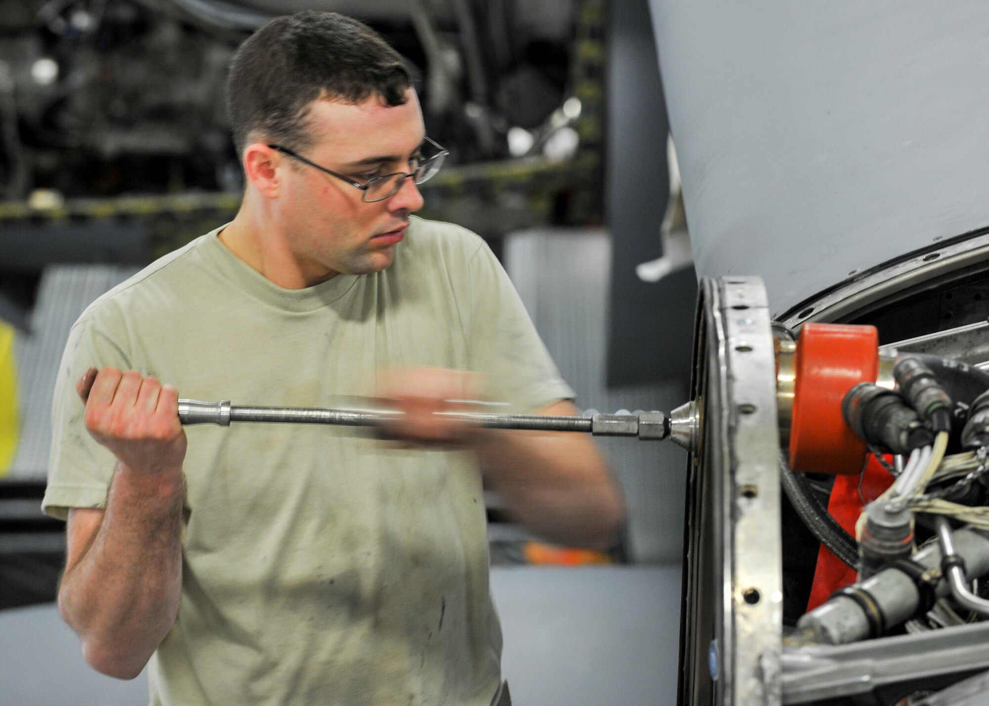 Senior Airman William Wright, an aerospace propulsion helper from the 910th Aircraft Maintenance Squadron here, uses a specialized tool to remove a guide cone from a C-130H Hercules aircraft engine mounting point, March 7, 2018.