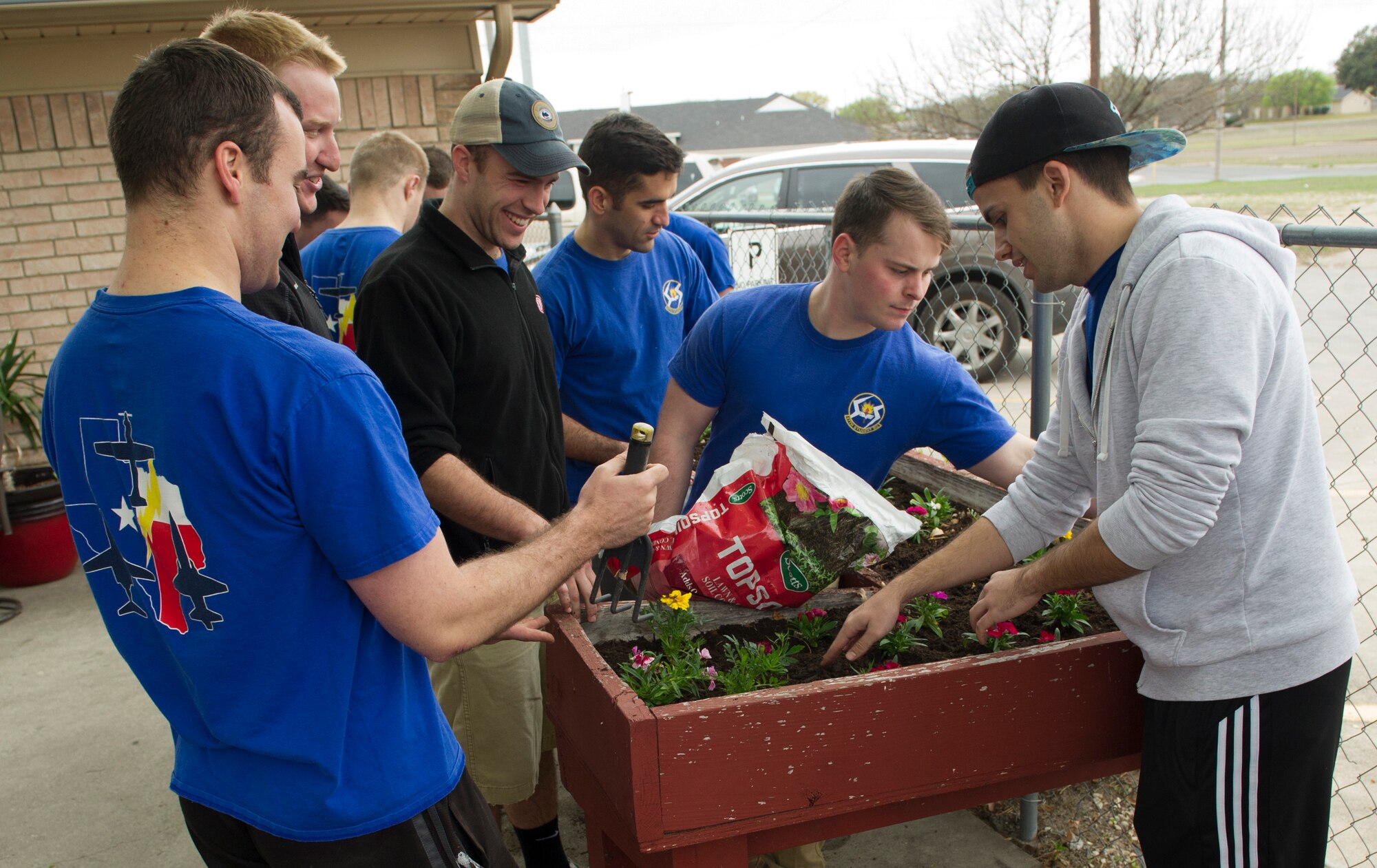 A group of volunteers from the 47th Student Squadron plant flowers at an elderly community in Del Rio, Texas, March 3, 2018. The volunteers were taking part in “STUS Serve Day,” where the 47th STUS gathered nearly 500 volunteers to help at various locations around the community. (U.S. Air Force photo/ Airman 1st Class Benjamin N. Valmoja)