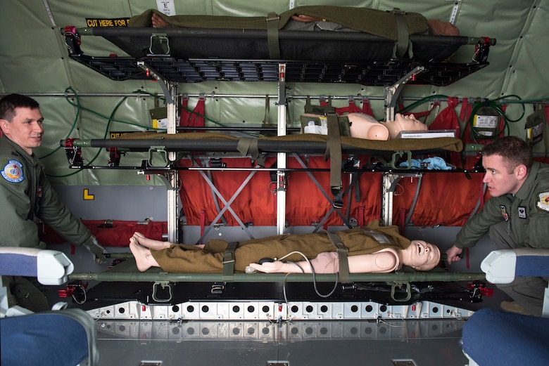 Capt. Michael Pieschel, 375th Aeromedical Evacuation Squadron standards and evaluations flight nurse, assists Master Sgt. Joseph Koch, 509th Weapons Squadron superintendent, move a patient litter during an aeromedical evacuation training at Fairchild Air Force Base, Washington, March 1, 2018. Practicing when to lift, move, stop and place equipment allows AE teams to maneuver patients with safety and efficiency while in the KC-135. (U.S. Air Force photo/Airman 1st Class Whitney Laine)