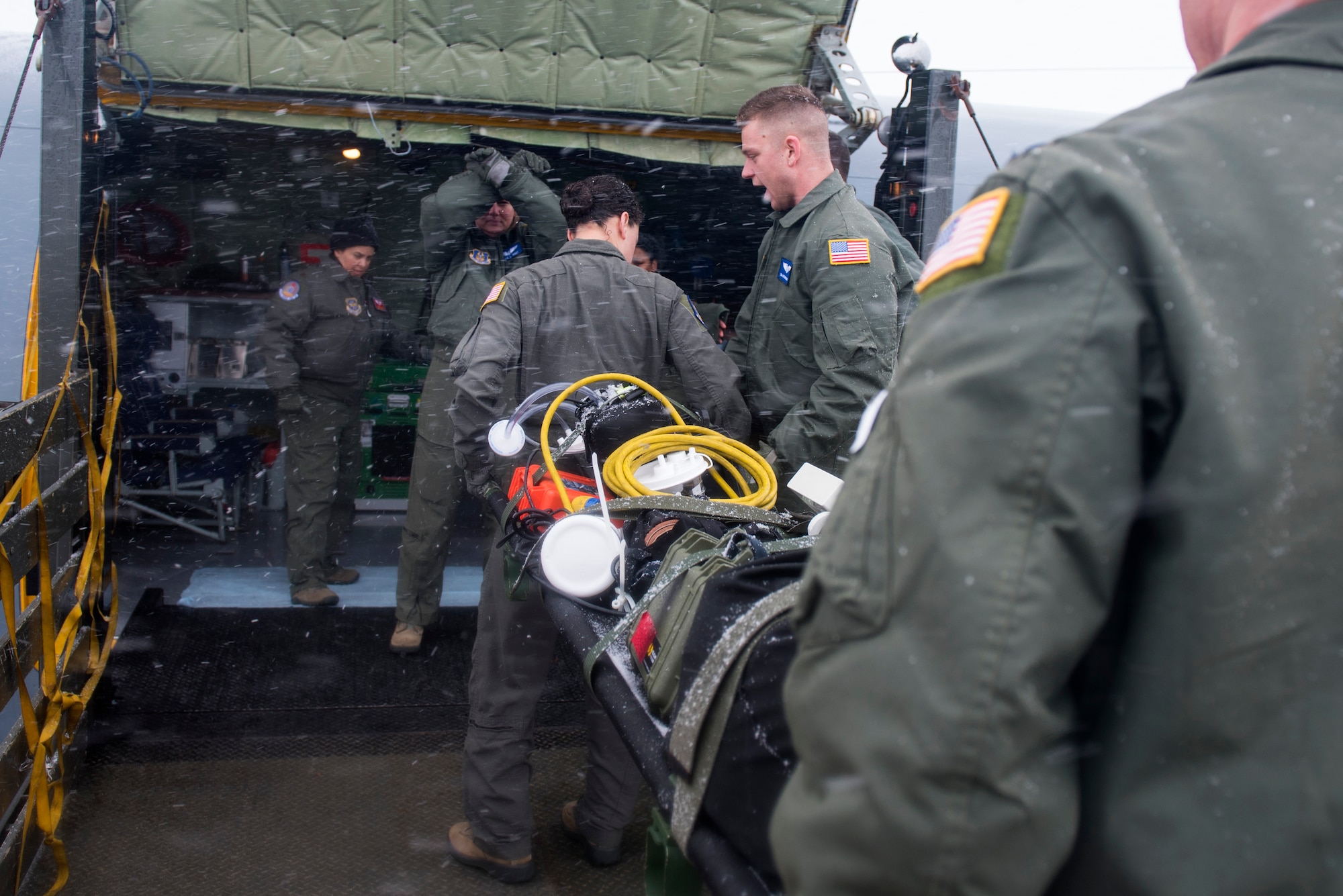Airmen from the 375th Aeromedical Evacuation Squadron transport a patient litter onto a KC-135 Stratotanker during an aeromedical evacuation training at Fairchild Air Force Base, Washington, March 1, 2018. Practicing when to lift, move, stop and place equipment allows AE teams to maneuver patients with safety and efficiency. (U.S. Air Force photo/Airman 1st Class Whitney Laine)