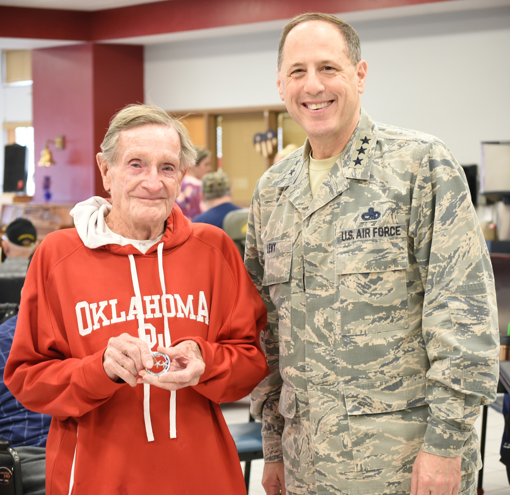 Norman Veterans Center resident Allen Vann shows off the challenge coin he received from Air Force Sustainment Center Commander Lt. Gen. Lee K. Levy II Feb. 28, 2018, in Norman, Oklahoma.  Mr. Vann was recognized for being named “2018 King of the Center” and turning 100 years old this year.