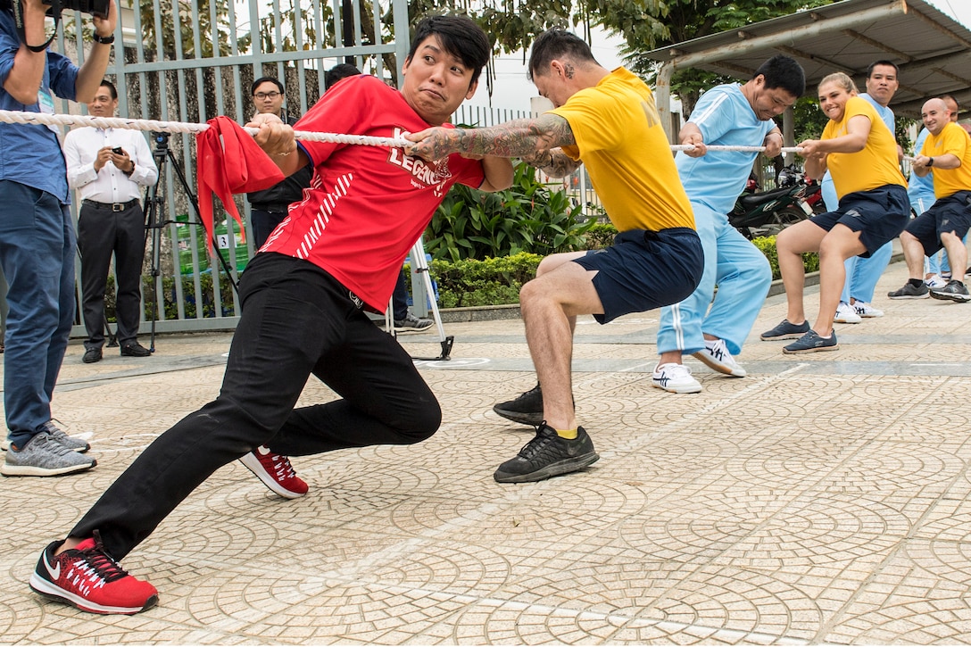 Sailors play tug of war with members of a mental health care center during a community service project.