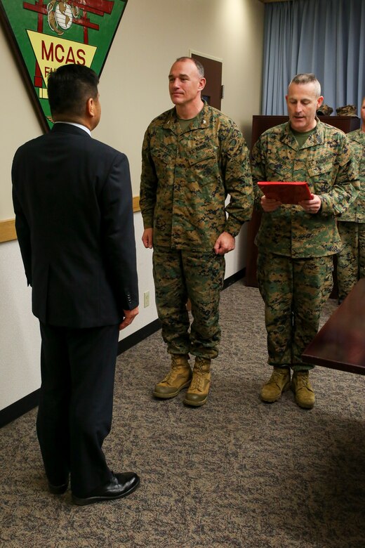 Police Chief Osamu Hamada, left and Col. Mark Coppess, center, stand at attention while Sgt. Major Jason Kappen reads a letter of appreciation during an award ceremony March 8 on Marine Corps Air Station Futenma, Okinawa, Japan. Hamada was recognized for his excellent service to Ginowan City and MCAS Futenma. Hamada is retiring as the Ginowan City Police Department chief. Coppess is the commanding officer of MCAS Futenma. Kappen is the Sgt. Major of MCAS Futenma. (U.S. Marine Corps photo by Pfc. Nicole Rogge)