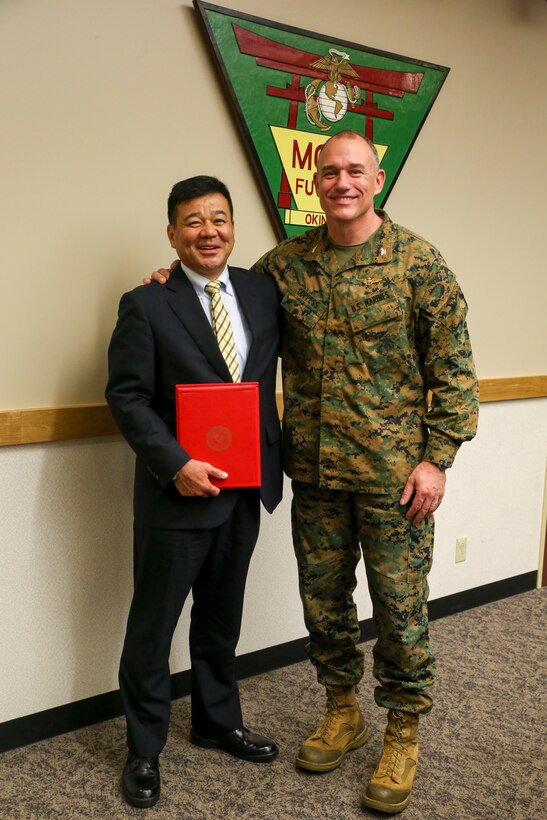 Police Chief Osamu Hamada, left, and Col. Mark Coppess pose for a photo during an award ceremony March 8 on Marine Corps Air Station Futenma, Okinawa, Japan. Chief Hamada was presented with a letter of appreciation for his excellent service to Ginowan City and MCAS Futenma. Hamada is retiring as the Ginowan City Police Department chief. Coppess is the commanding officer of MCAS Futenma. (U.S. Marine Corps photo by Pfc. Nicole Rogge)