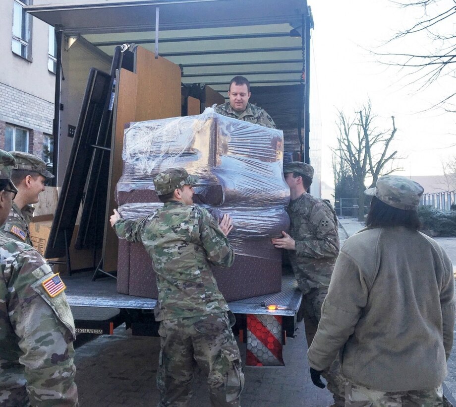 Army Capt. Jason M. Spalding, top center, 21st Theater Sustainment Command liaison officer, Mission Command Element, helps unload furniture at the Morale, Welfare and Recreation building in Poznan, Poland, Feb. 13, 2018. Spalding has transported large quantities over the last few months throughout the Atlantic Resolve area of operations to improve service members’ quality of life. Army photo by Staff Sgt. Scott J. Evans