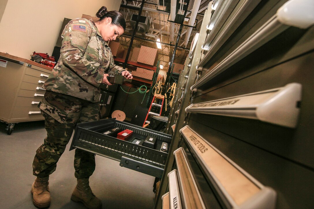 A soldier inspects equipment from an inventory form.