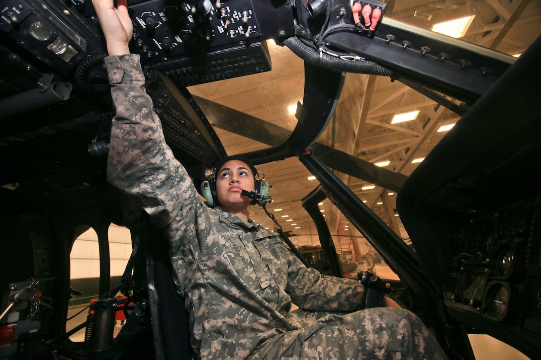 A soldier performs avionics checks on a UH-60L Black Hawk helicopter.