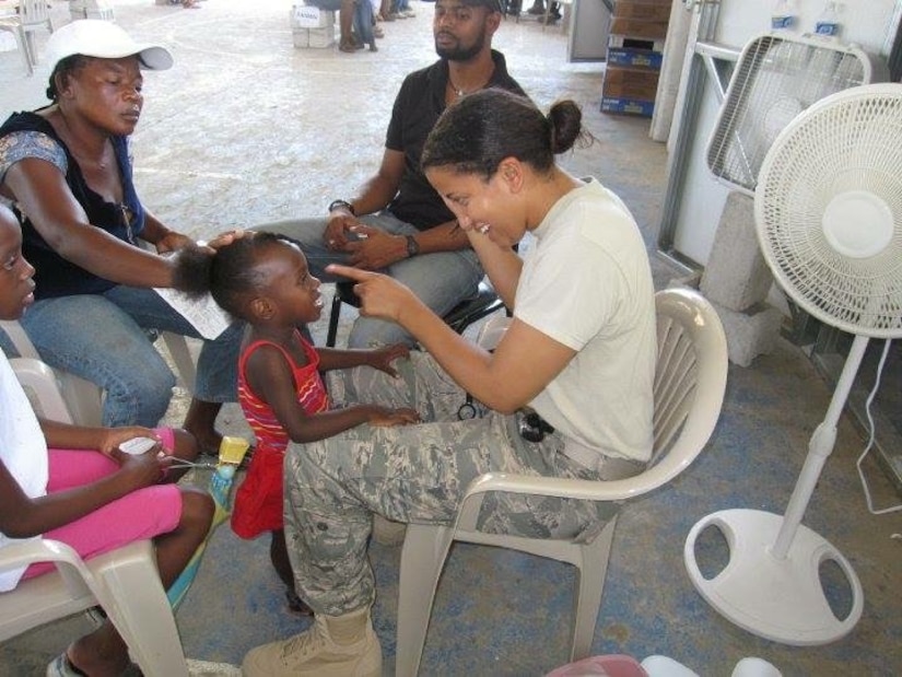 Maj. Khadidja Harrell, Chief Global Health Engagement at U.S. Pacific Command, checks up on a young patient in Haiti, May 2010. Harrell, who is a pediatrician by trade, visited with many patients as part of a medical readiness training exercise after the 2010 Haiti earthquake. (Courtesy photo)