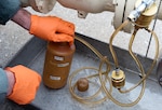 Fuels lab technician pull fuel samples and testing them.