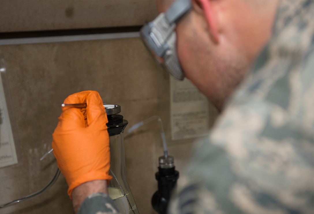 Fuels lab technician pull fuel samples and testing them.