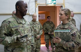 Brig. Gen. Sylvester Cannon, commanding general of the 135th Sustainment Command, and deputy commanding general of the 1st Theater Sustainment Command-OCP, left, is briefed by 1st Lt. Keerstin Beitter, deputy chief of the 49th Theater Gateway and officer-in-charge of the Camp Buehring gateway.