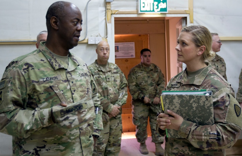 Brig. Gen. Sylvester Cannon, commanding general of the 135th Sustainment Command, and deputy commanding general of the 1st Theater Sustainment Command-OCP, left, is briefed by 1st Lt. Keerstin Beitter, deputy chief of the 49th Theater Gateway and officer-in-charge of the Camp Buehring gateway.