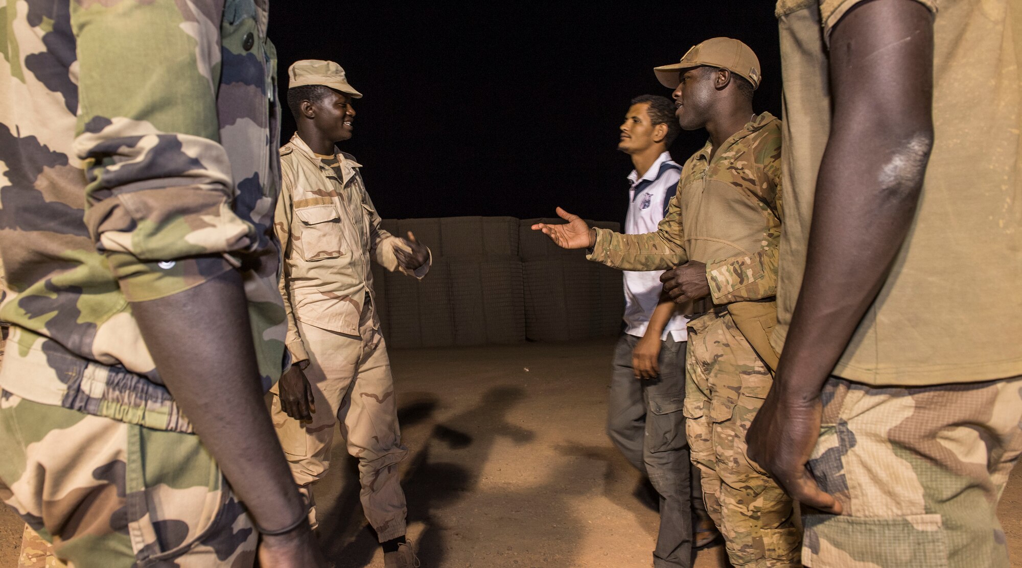 U.S. Air Force Staff Sgt. Mackenzie Isidor, 822nd Expeditionary Base Defense Squadron fire team leader, communicates with members of the Forces Armées Nigeriennes, during a night shift at Nigerien Air Base 201, in Agadez, Niger, Feb. 26, 2018. The U.S. military is in Agadez at the request of the Government of Niger, and the U.S. remain committed to helping our African partners protect their borders with matters of national security, and with other efforts important to the citizens of Niger. (U.S. Air Force photo by Tech. Sgt. Nick Wilson)