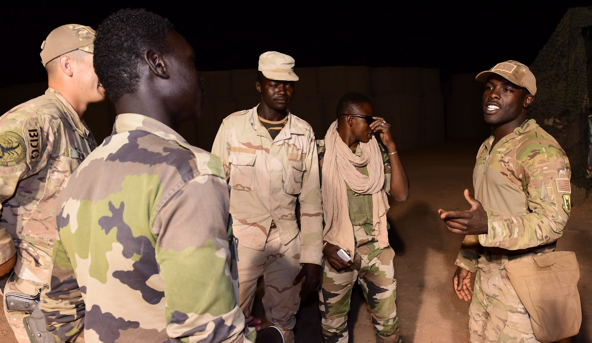 U.S. Air Force Staff Sgt. Mackenzie Isidor, 822nd Expeditionary Base Defense Squadron fire team leader, briefs Airmen and members of the Forces Armées Nigeriennes, during a night shift at Nigerien Air Base 201, in Agadez, Niger, Feb. 26, 2018. Airmen and their host nation partners in Africa work closely in an effort to support mutual security goals and objectives in Africa. (U.S. Air Force photo by Tech. Sgt. Nick Wilson)