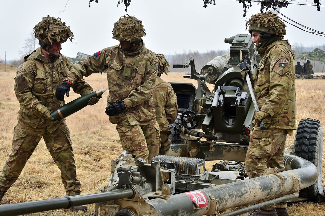 British soldiers prepare to load a round into a 105 mm howitzer.