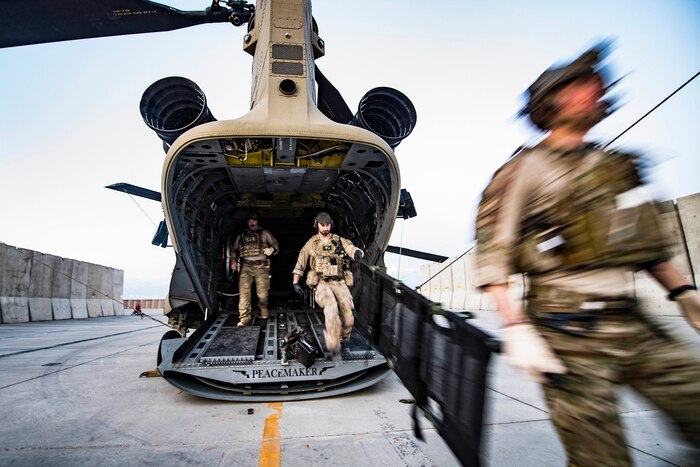 Airmen leave the back on an aircraft.