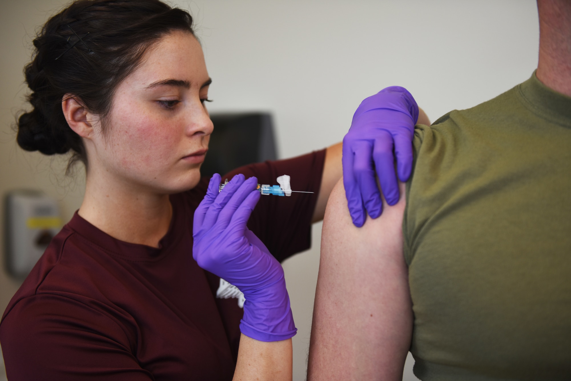 Airman 1st Class Kayla Jaramillo, an aerospace medical technician at the Buckley Air Force Base Colfax Clinic, in Aurora, Colorado administers a vaccine to a patient Feb 9, 2018. Out of hundreds of paintings submitted for the 2017 Air Force Art Contest, Jaramillo placed first in the Adult Novice Category with a painting she titled “Swallow your Pride, Life isn’t Fair”. (U.S. Air Force photo by Senior Airman Jessica B. Kind)