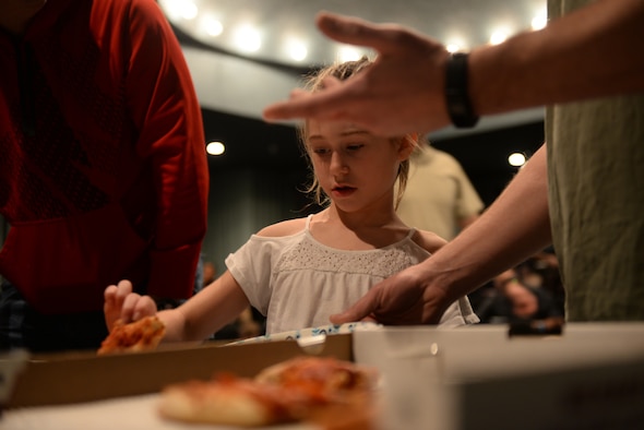 A child picks a slice of pizza before watching a movie during a Hearts Apart event at the Elks Theater in Rapid City, S.D., March 3, 2018. Each quarter, the Airman and Family Readiness Center at Ellsworth Air Force Base, S.D., hosts an event like this, but the location and activity will vary. (U.S. Air Force photo by Airman 1st Class Nicolas Z. Erwin)