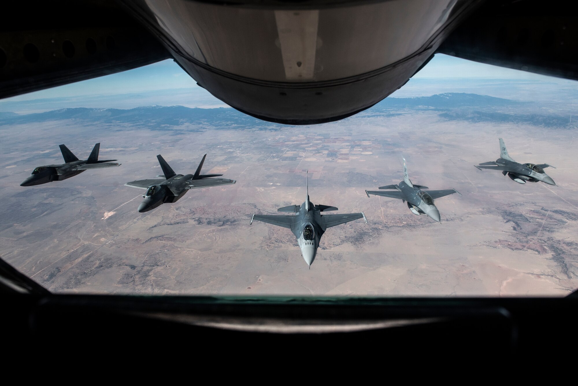 Two F-22 Raptors and three F-16 Fighting Falcons fly in formation behind a KC-135 Stratotanker while returning home from the Heritage Flight Training Course at Davis-Monthan Air Force Base, Ariz., March 5, 2018. The course brings pilots, maintainers and aircraft from various generations together to train for dissimilar formation flights to demonstrate the Air Force's history of airpower. (U.S. Air Force photo by Senior Airman Destinee Sweeney)
