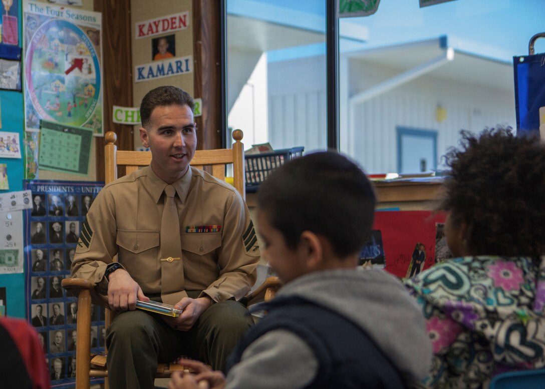 Sgt. Seth Laird, Range Safety Officer, with Marine Training Unit, converses with students in support of Read Across America at Friendly Hills Elementary School in Joshua Tree, Calif., on March 2, 2018.  Read Across America is an annual reading motivation and awareness program that calls for every child in every community to celebrate reading. (U.S. Marine Corps Photo by Cpl. Francisco J. Britoramirez)